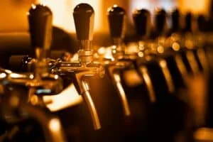 
creatively blurred faucets beer pub with defocused bokeh artistic digital noise golden row taps taproom